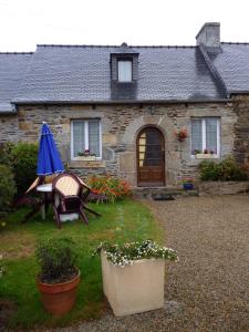 una casa con mesa y sillas en el patio en Les Gites de Kerroyal, en Garlan