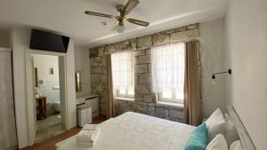 a bedroom with a bed and a stone wall at Oberj d'Azur Alaçatı in Alaçatı