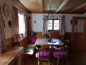 uma sala de jantar com uma mesa de madeira e cadeiras em Reithamer Bergfensterl em Warngau