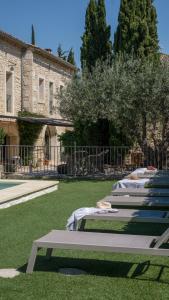 a row of lounges on the grass in front of a building at L'Ostal Saint Hilaire d'Ozilhan - Bed & Breakfast - Spa in Saint-Hilaire-dʼOzilhan