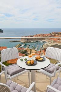 una mesa con comida en la parte superior de un balcón en Hedera Estate, Hedera A32, en Dubrovnik
