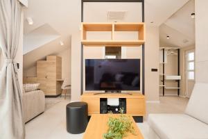 sala de estar con TV de pantalla plana en un centro de entretenimiento de madera en Hedera Estate, Hedera A32, en Dubrovnik