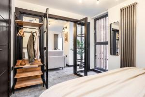 een slaapkamer met een bed en een deur naar een badkamer bij The Brewers Rooms Contemporary Aparthotel in Edinburgh