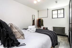 Un dormitorio con una gran cama blanca y una ventana en The Brewers Rooms Contemporary Aparthotel, en Edimburgo
