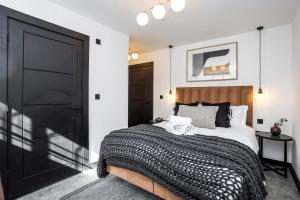 1 dormitorio con cama y puerta negra en The Brewers Rooms Contemporary Aparthotel, en Edimburgo