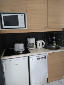 a kitchen with a sink and a microwave at appartement vue sur mer in Talmont