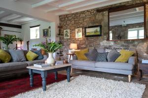 a living room with couches and a stone wall at Little Underhill in Oswestry