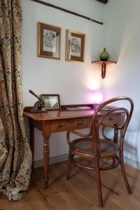 an old wooden desk with a chair and a lamp at Little Underhill in Oswestry