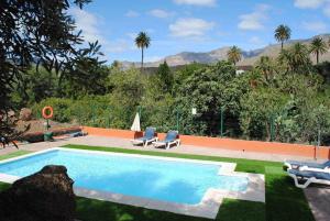 a swimming pool with two lounge chairs at Casa Rural El Palmeral del Valle in Santa Lucía