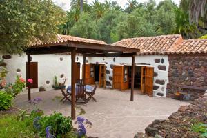 a patio in front of a house with a roof at Casa Rural El Palmeral del Valle in Santa Lucía