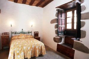 a bedroom with a bed and a window at Casa rural EL Olivar - El Orujo in Santa Lucía