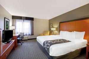 una camera d'albergo con un letto grande e una scrivania di La Quinta by Wyndham Harrisburg Airport Hershey a Harrisburg