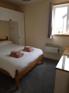 a bedroom with a bed with two towels on it at Lindisfarne Self Catering in Navershaw