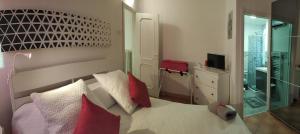 um quarto com uma cama com almofadas vermelhas e brancas em Casetta di Myra em Bari