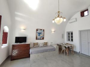a room with a bed and a desk and a television at Dreamer's secret villa in Emporio Santorini