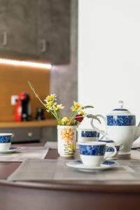 巴勒卡斯寵隆的住宿－Achilles Maisonette，一张桌子上放着蓝色和白色的杯子和鲜花