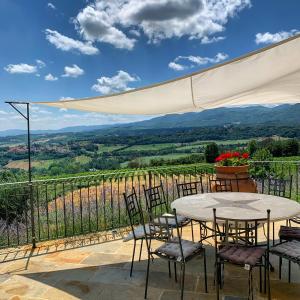 a table and chairs on a patio with a view at La Casa dell' Ambra - Charming old barn in Rignano sullʼArno