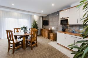 a kitchen and dining room with a table and chairs at Hotel Kotarz Spa&Wellness in Brenna