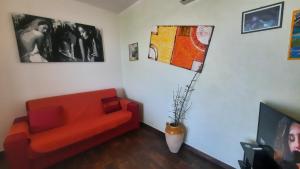 CasamassellaにあるFata Morganaの赤いソファと写真が飾られたリビングルーム