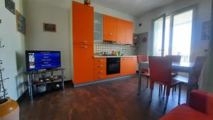 CasamassellaにあるFata Morganaのキッチン(オレンジ色のキャビネット、テーブル、テレビ付)