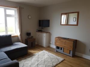 a living room with a couch and a mirror at Lindisfarne Self Catering in Navershaw