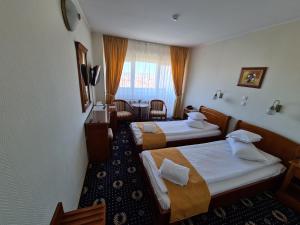 クルジュ・ナポカにあるHotel Belvedereのベッド2台と窓が備わるホテルルームです。