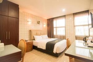 a hotel room with a bed and a desk at Suwara Hotel Kepong KL in Kuala Lumpur