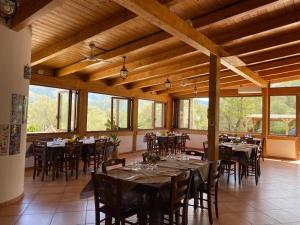 a dining room with tables and chairs and windows at Il Moro della Molpa in Palinuro