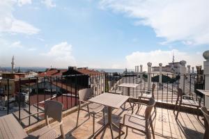 a patio with tables and chairs on a roof at SEVEN ROSES APART HOTEL in Istanbul