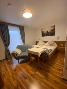 a bedroom with a bed and a table and a chair at Landhaus Lackner in Heiligenblut