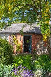 uma casa de tijolos com flores no quintal em Courtyard Cottage em Oswestry