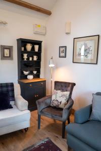 uma sala de estar com um sofá, uma cadeira e uma mesa em Courtyard Cottage em Oswestry