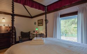 a bedroom with a large bed and a window at 1720 Quinta da Cancela - Winery & Farmhouse in Guimarães