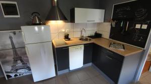 a small kitchen with a refrigerator and a sink at Apartment Vdovjak in Malinska +3 photos