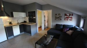 salon z kanapą i kuchnią w obiekcie Apartment Vdovjak w mieście Malinska