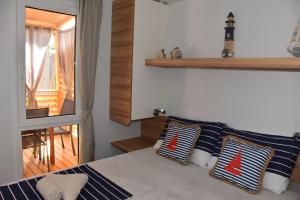 um quarto com uma cama com almofadas azuis e brancas em Mobile Home Camping park Soline Gapi house em Biograd na Moru