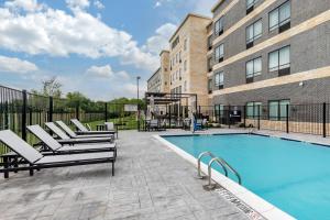 uma piscina com espreguiçadeiras ao lado de um edifício em Staybridge Suites Grand Prairie Near Epic Central, an IHG Hotel em Grand Prairie