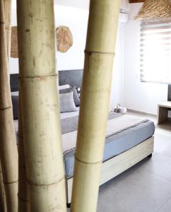 Bett in einem Zimmer mit Bambusstöcken in der Unterkunft Vabel Skiathos in Skiathos-Stadt