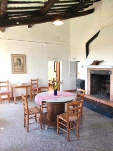 Habitación con mesa, sillas y chimenea. en Podere San Giuseppe, en Acquapendente