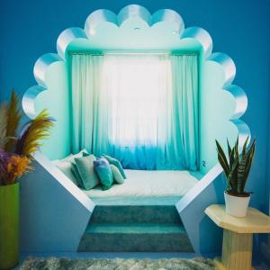 Bett in einem Zimmer mit blauer Wand in der Unterkunft The Courtyard Suite by Margate Suites in Margate