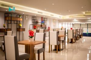 - une salle à manger avec des tables, des chaises et des fleurs à l'étage dans l'établissement Terrace View 3 - Hotel Apartments, à Dammam