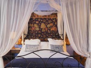 a bedroom with a canopy bed with white curtains at Las Moradas Del Temple in Mirambel