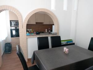 a dining room with a table and a kitchen at Ilona Apartmanház in Siófok