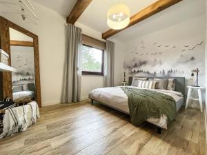 a bedroom with a bed with birds on the wall at Kurs Siemiany, dom z jacuzzi i sauną na wyłączność in Siemiany