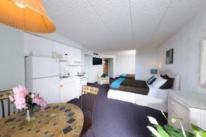 a living room with a bed and a table in a room at Bal Harbour Hotels in Wildwood Crest