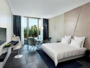 a bedroom with a large bed and a living room at Swissôtel Resort Bodrum Beach in Turgutreis