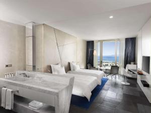 a hotel room with a large bed and a bathroom at Swissôtel Resort Bodrum Beach in Turgutreis