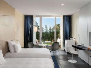 a hotel room with two beds and a desk at Swissôtel Resort Bodrum Beach in Turgutreis