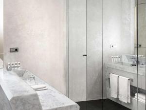 a white bathroom with two sinks and a shower at Swissôtel Resort Bodrum Beach in Turgutreis