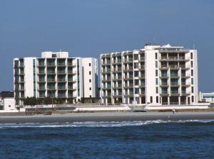 dwa duże białe budynki na plaży w pobliżu wody w obiekcie Bal Harbour Hotels w mieście Wildwood Crest